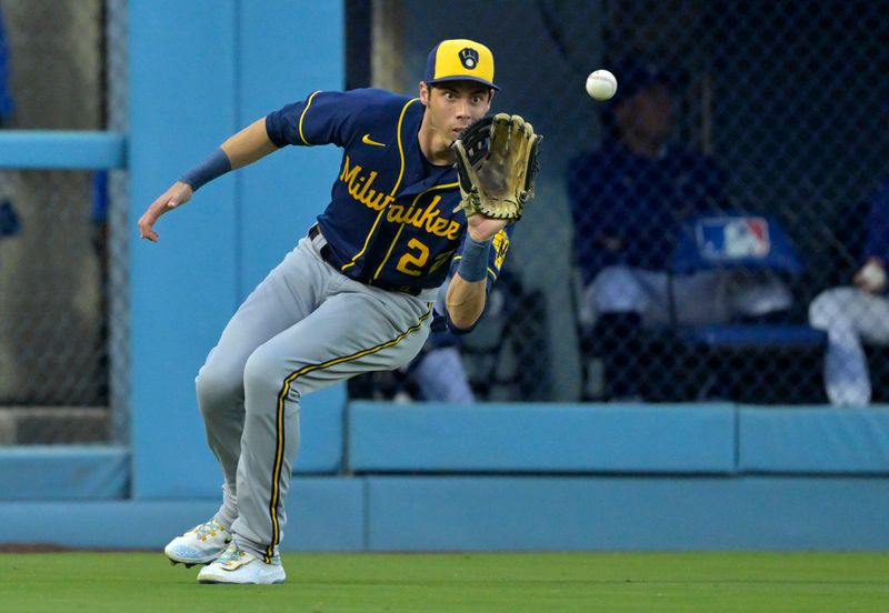 Aug 17, 2023; Los Angeles, California, USA;  Milwaukee Brewers left fielder Christian Yelich (22) fields a single by Los Angeles Dodgers right fielder Mookie Betts (50) in the first inning at Dodger Stadium. Mandatory Credit: Jayne Kamin-Oncea-USA TODAY Sports