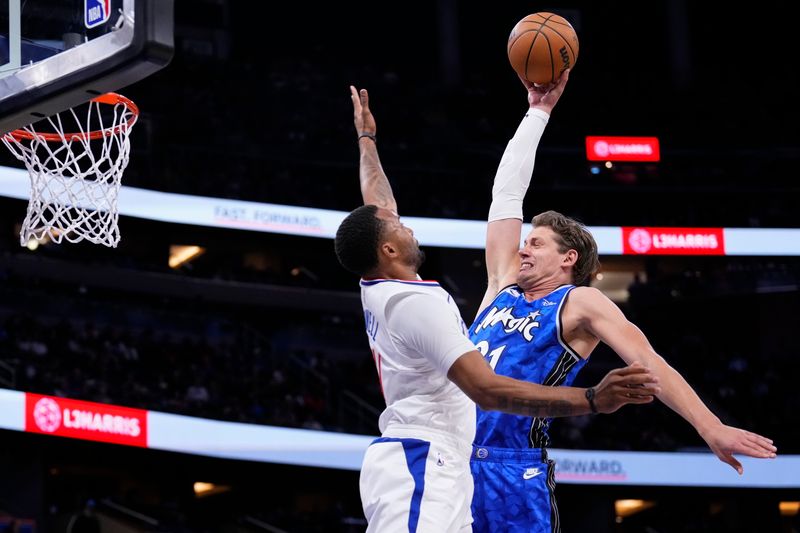 ORLANDO, FLORIDA - MARCH 29: Moritz Wagner #21 of the Orlando Magic dunks the ball over Norman Powell #24 of the Los Angeles Clippers during the second quarter at Kia Center on March 29, 2024 in Orlando, Florida. NOTE TO USER: User expressly acknowledges and agrees that, by downloading and or using this photograph, User is consenting to the terms and conditions of the Getty Images License Agreement. (Photo by Rich Storry/Getty Images)