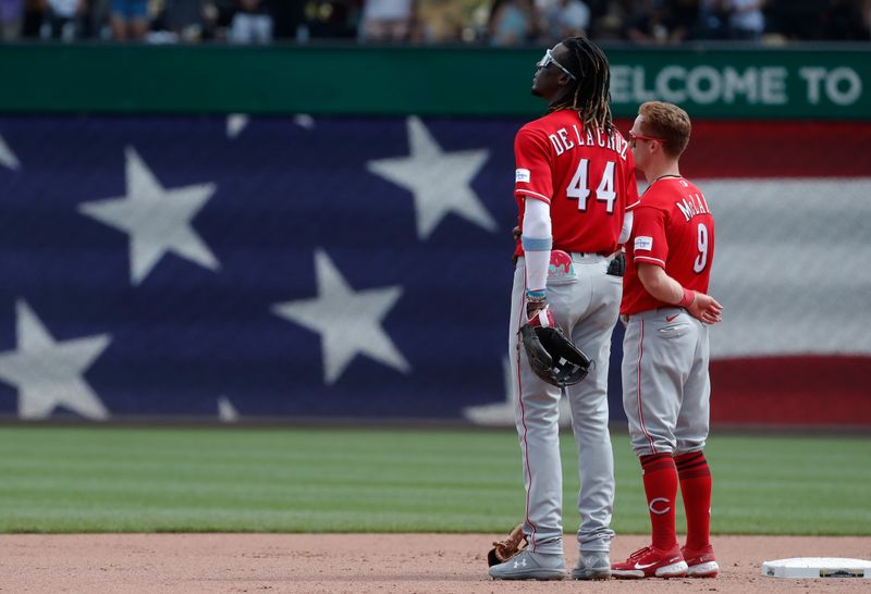 Aug 13, 2023; Pittsburgh, Pennsylvania, USA; Cincinnati Reds shortstop Elly De La Cruz (44) and second baseman Matt McLain (9) stand for the playing of God Bless America during the seventh inning stretch against the Pittsburgh Pirates at PNC Park. Mandatory Credit: Charles LeClaire-USA TODAY Sports