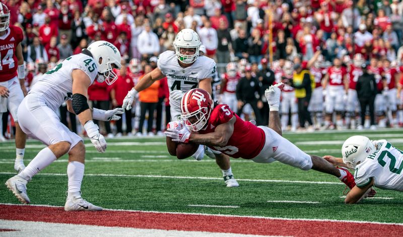 Oct 16, 2021; Bloomington, Indiana, USA; Indiana Hoosiers running back Stephen Carr (5) dives into the end zone for a touchdown during the second half against the Michigan State Spartans at Memorial Stadium. Spartans win 20-15.  Mandatory Credit: Marc Lebryk-USA TODAY Sports