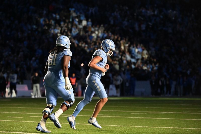 Nov 11, 2023; Chapel Hill, North Carolina, USA; North Carolina Tar Heels quarterback Drake Maye (10) and offensive lineman Diego Pounds (61) leave the field after going up by 8 in double overtime at Kenan Memorial Stadium. Mandatory Credit: Bob Donnan-USA TODAY Sports