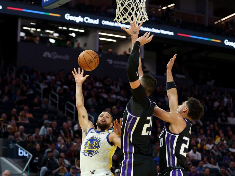 SAN FRANCISCO, CALIFORNIA - OCTOBER 11: Stephen Curry #30 of the Golden State Warriors goes up for a shot on Alex Len #25 and Colby Jones #20 of the Sacramento Kings during the first half of their preseason game at Chase Center on October 11, 2024 in San Francisco, California.  NOTE TO USER: User expressly acknowledges and agrees that, by downloading and/or using this photograph, user is consenting to the terms and conditions of the Getty Images License Agreement.  (Photo by Ezra Shaw/Getty Images)