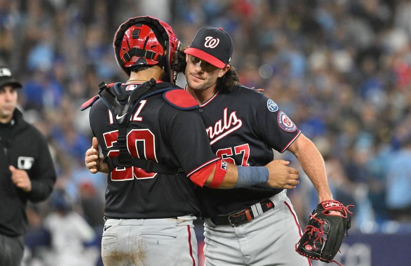 Aug 29, 2023; Toronto, Ontario, CAN;  Washington Nationals relief pitcher Kyle Finnegan (67) and catcher Keibert Ruiz (20) celebrate a win over the Toronto Blue Jays at Rogers Centre. Mandatory Credit: Dan Hamilton-USA TODAY Sports