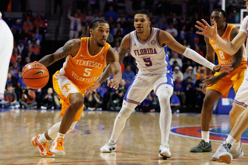 Jan 7, 2025; Gainesville, Florida, USA; Tennessee Volunteers guard Zakai Zeigler (5) drives to the basket away from Florida Gators guard Will Richard (5) during the first half at Exactech Arena at the Stephen C. O'Connell Center. Mandatory Credit: Matt Pendleton-Imagn Images