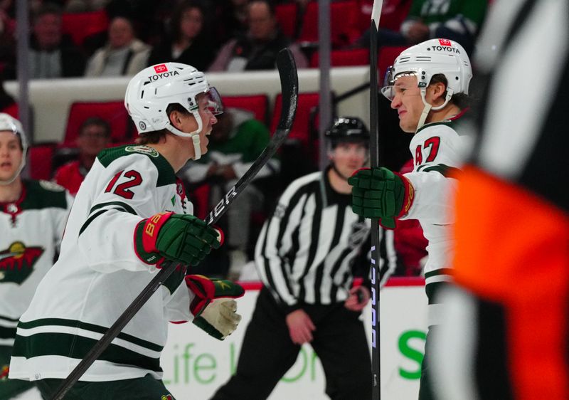 Jan 21, 2024; Raleigh, North Carolina, USA;  Minnesota Wild left wing Kirill Kaprizov (97) celebrates his goal with left wing Matt Boldy (12) against the Carolina Hurricanes during the second period at PNC Arena. Mandatory Credit: James Guillory-USA TODAY Sports