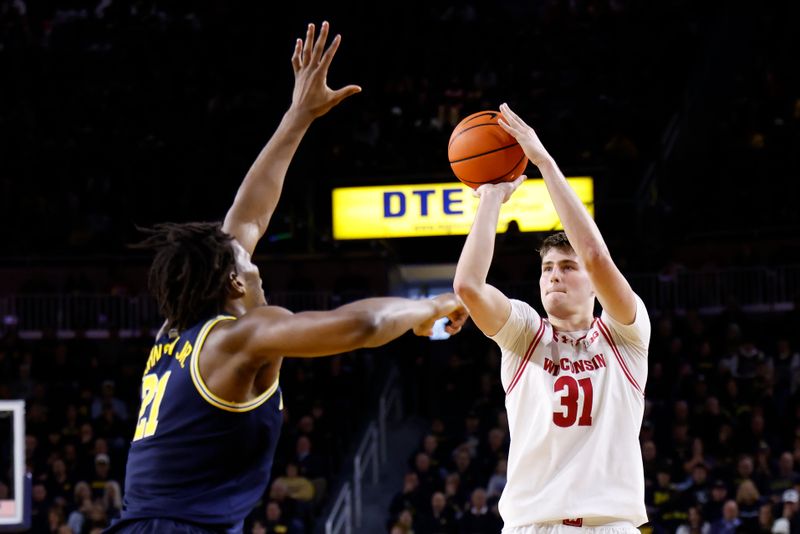 Jan 10, 2026; Ann Arbor, Michigan, USA;  Wisconsin Badgers forward Nolan Winter (31) shoots on Michigan Wolverines forward Morez Johnson Jr. (21) in the second half at Crisler Center. Mandatory Credit: Rick Osentoski-Imagn Images