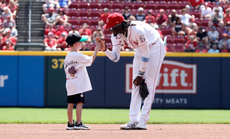 Aug 20, 2023; Cincinnati, Ohio, USA; Cincinnati Reds third baseman Elly De La Cruz (44) reacts with a young fan prior to a game with the Toronto Blue Jays at Great American Ball Park. Mandatory Credit: David Kohl-USA TODAY Sports