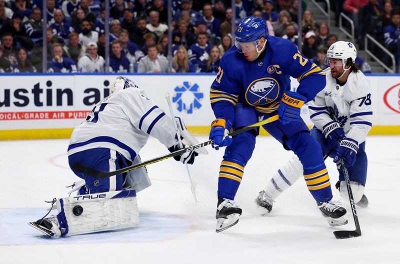 Dec 21, 2023; Buffalo, New York, USA;  Toronto Maple Leafs goaltender Martin Jones (31) makes a pad save on Buffalo Sabres right wing Kyle Okposo (21) during the second period at KeyBank Center. Mandatory Credit: Timothy T. Ludwig-USA TODAY Sports