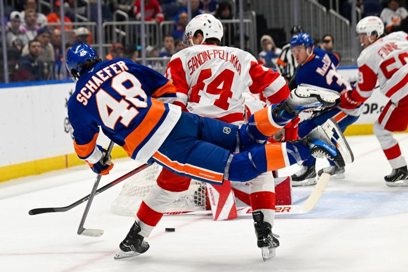 Oct 23, 2025; Elmont, New York, USA;  New York Islanders defenseman Matthew Schaefer (48) attempts a diving shot defended by Detroit Red Wings defenseman Axel Sandin-Pellikka (44) during the second period at UBS Arena. Mandatory Credit: Dennis Schneidler-Imagn Images