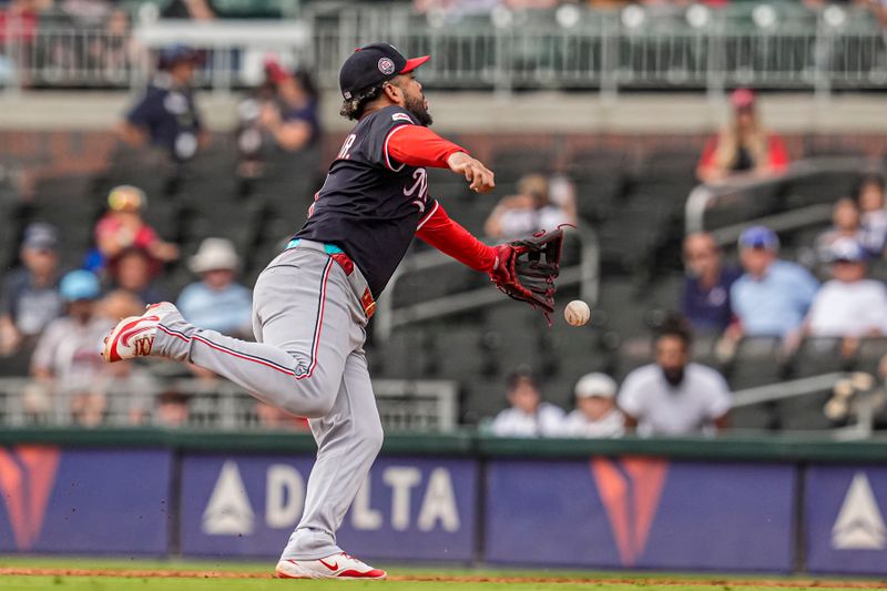 Sep 24, 2025; Cumberland, Georgia, USA; Washington Nationals second baseman Luis Garcia Jr. (2) retires Atlanta Braves catcher Drake Baldwin (30) (not shown) by flipping the ball from his glove for the final out during the ninth inning at Truist Park. Mandatory Credit: Dale Zanine-Imagn Images