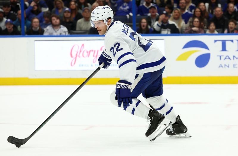 Nov 30, 2024; Tampa, Florida, USA; Toronto Maple Leafs defenseman Jake McCabe (22) skates with the puck against the Tampa Bay Lightning during the first period at Amalie Arena. Mandatory Credit: Kim Klement Neitzel-Imagn Images