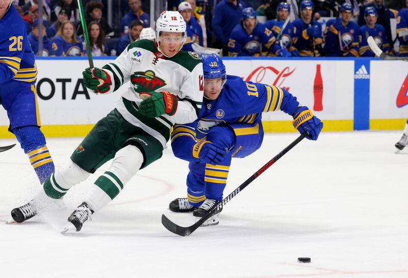 Nov 10, 2023; Buffalo, New York, USA;  Minnesota Wild left wing Matt Boldy (12) looks to play the puck as Buffalo Sabres defenseman Henri Jokiharju (10) defends during the third period at KeyBank Center. Mandatory Credit: Timothy T. Ludwig-USA TODAY Sports