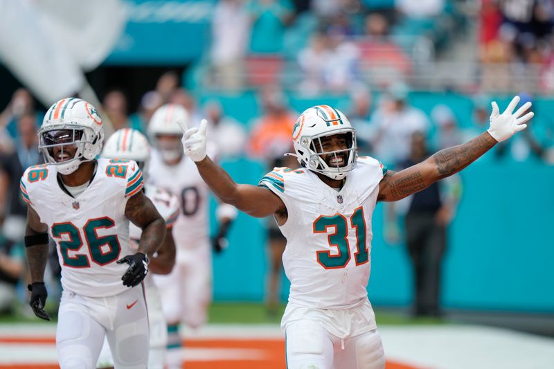 Miami Dolphins running back Raheem Mostert (31) celebrates scoring a touchdown during the second half of an NFL football game against the New England Patriots, Sunday, Oct. 29, 2023, in Miami Gardens, Fla. (AP Photo/Wilfredo Lee)