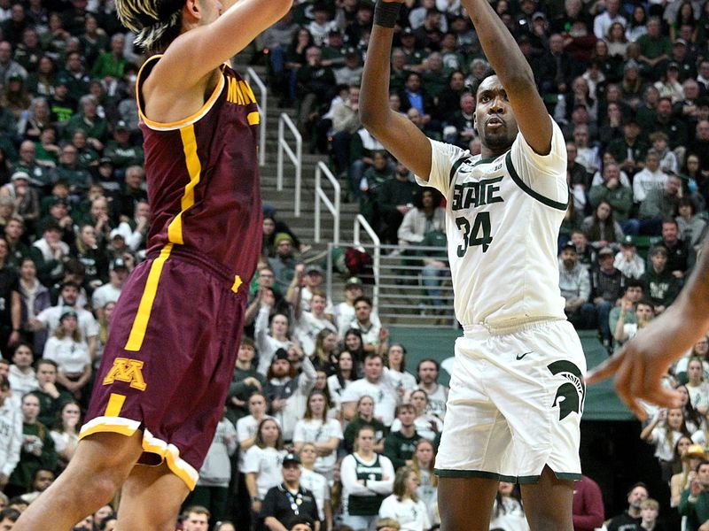 Jan 28, 2025; East Lansing, Michigan, USA;  Michigan State Spartans forward Xavier Booker (34) shoots past Minnesota Golden Gophers forward Dawson Garcia (3) during the second half at Jack Breslin Student Events Center. Mandatory Credit: Dale Young-Imagn Images