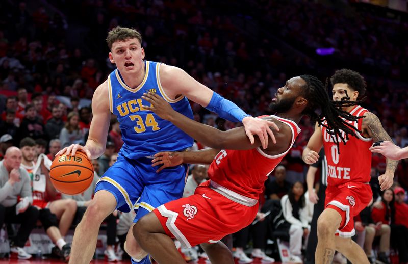 Jan 17, 2026; Columbus, Ohio, USA; UCLA Bruins forward Tyler Bilodeau (34) drives to the basket as Ohio State Buckeyes guard Bruce Thornton (2) defends during the first half at Value City Arena. Mandatory Credit: Joseph Maiorana-Imagn Images