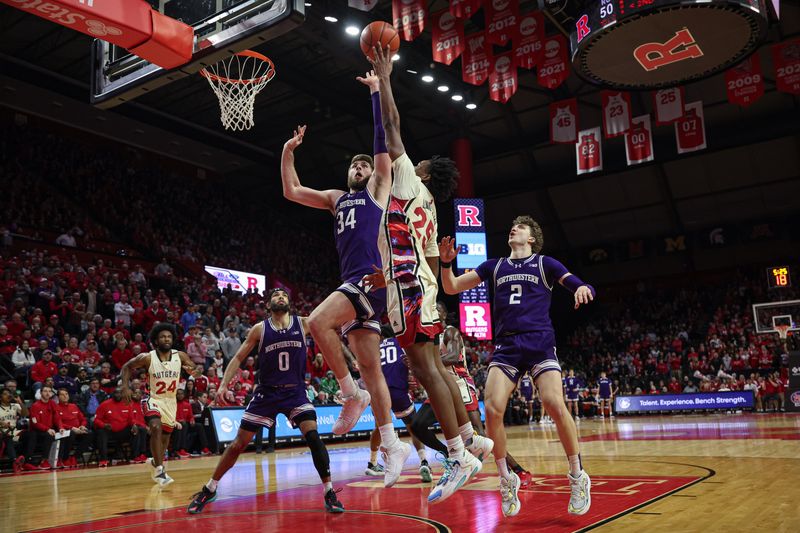 Feb 15, 2024; Piscataway, New Jersey, USA; Northwestern Wildcats center Matthew Nicholson (34) blocks a shot by Rutgers Scarlet Knights guard Jeremiah Williams (25) during the second half at Jersey Mike's Arena. Mandatory Credit: Vincent Carchietta-USA TODAY Sports