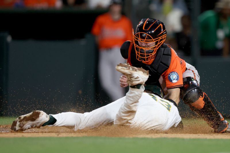 Jun 7, 2025; West Sacramento, California, USA; Baltimore Orioles catcher Maverick Handley (98) covers home plate as Athletics left fielder JJ Bleday (33) slides home during the fifth inning at Sutter Health Park. Mandatory Credit: Dennis Lee-Imagn Images