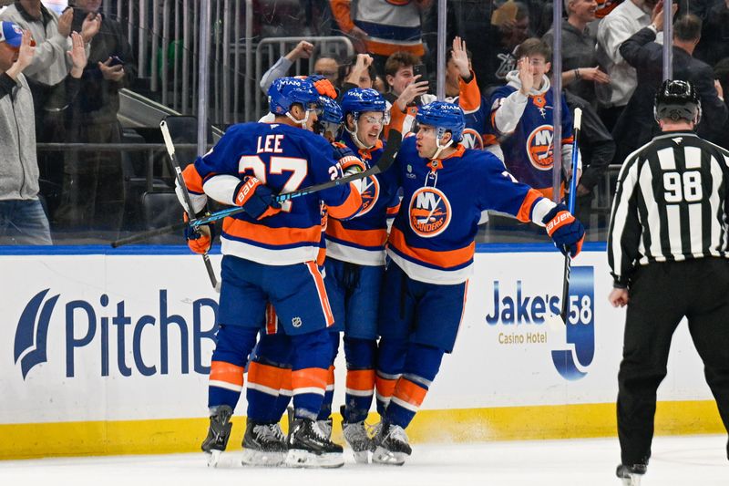 Jan 6, 2026; Elmont, New York, USA;  New York Islanders left wing Anders Lee (27), New York Islanders center Mathew Barzal (13) and New York Islanders defenseman Tony Deangelo (77) celebrate the goal byNew York Islanders left wing Anthony Duclair (11) against the New Jersey Devils during the first period at UBS Arena. Mandatory Credit: Dennis Schneidler-Imagn Images