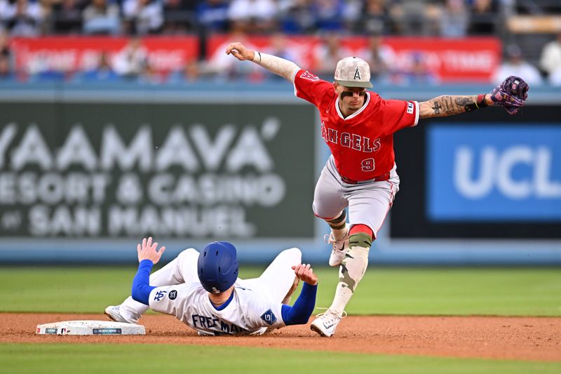 May 17, 2025; Los Angeles, California, USA; Los Angeles Dodgers first base Freddie Freeman (5) slides to second base against Los Angeles Angels shortstop Zach Neto (9) in the third inning at Dodger Stadium. Mandatory Credit: Jonathan Hui-Imagn Images