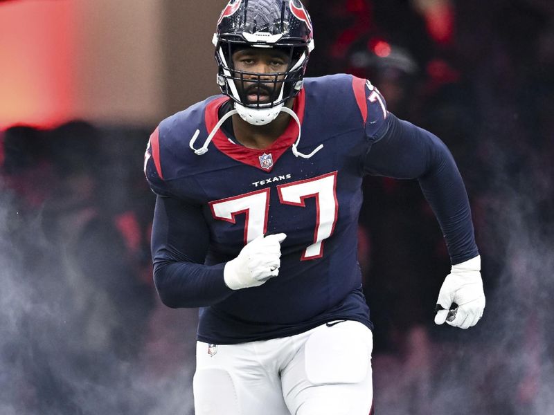 Houston Texans offensive tackle George Fant (77) run on to the field prior to an NFL football game against the Denver Broncos, Sunday, Dec 3, 2023, in Houston. (AP Photo/Maria Lysaker)