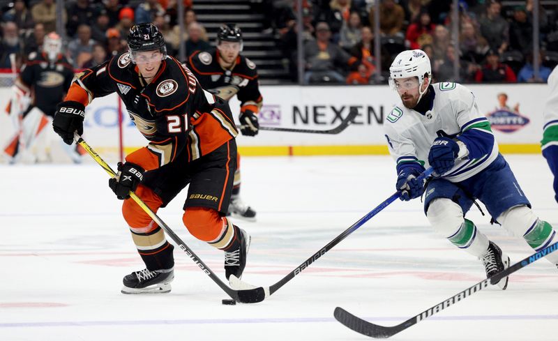 Mar 3, 2024; Anaheim, California, USA; Anaheim Ducks center Isac Lundestrom (21) battles with Vancouver Canucks right wing Conor Garland (8) during the second period at Honda Center. Mandatory Credit: Jason Parkhurst-USA TODAY Sports