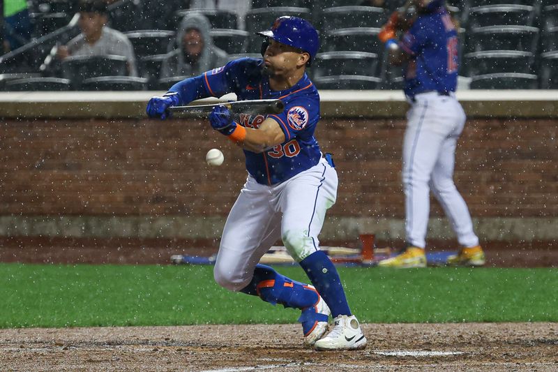 Aug 7, 2023; New York City, New York, USA; New York Mets center fielder Rafael Ortega (30) bunts for a single during the sixth inning against the Chicago Cubs at Citi Field. Mandatory Credit: Vincent Carchietta-USA TODAY Sports