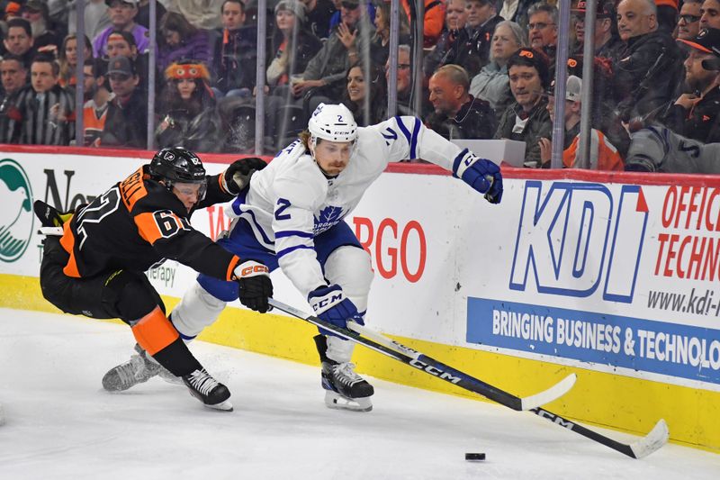 Mar 19, 2024; Philadelphia, Pennsylvania, USA; Toronto Maple Leafs defenseman Simon Benoit (2) and Philadelphia Flyers right wing Olle Lycksell (62) reach for the puck during the first period at Wells Fargo Center. Mandatory Credit: Eric Hartline-USA TODAY Sports