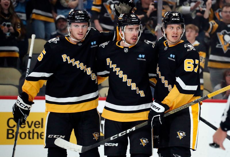 Oct 26, 2023; Pittsburgh, Pennsylvania, USA; Pittsburgh Penguins right wing Reilly Smith (middle) is congratulated by defenseman Ryan Shea (5) and right wing Rickard Rakell (67) after Smith scored a power play goal against the Colorado Avalanche during the first period at PPG Paints Arena. Mandatory Credit: Charles LeClaire-USA TODAY Sports