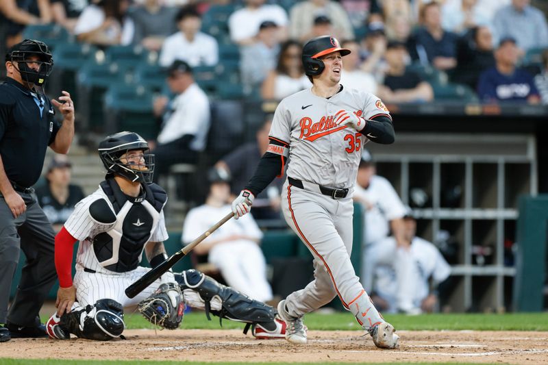 May 23, 2024; Chicago, Illinois, USA; Baltimore Orioles catcher Adley Rutschman (35) hits a RBI single against the Chicago White Sox during the third inning at Guaranteed Rate Field. Mandatory Credit: Kamil Krzaczynski-USA TODAY Sports