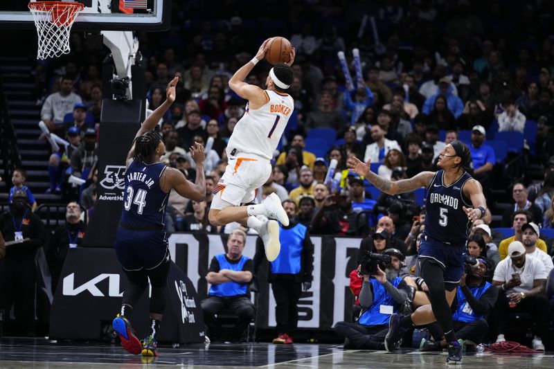 ORLANDO, FLORIDA - JANUARY 28: Devin Booker #1 of the Phoenix Suns goes up for a shot against Wendell Carter Jr. #34 of the Orlando Magic during the fourth quarter at Kia Center on January 28, 2024 in Orlando, Florida. NOTE TO USER: User expressly acknowledges and agrees that, by downloading and or using this photograph, User is consenting to the terms and conditions of the Getty Images License Agreement. (Photo by Rich Storry/Getty Images)