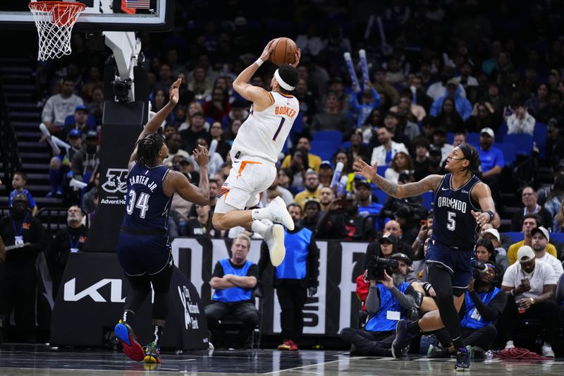 ORLANDO, FLORIDA - JANUARY 28: Devin Booker #1 of the Phoenix Suns goes up for a shot against Wendell Carter Jr. #34 of the Orlando Magic during the fourth quarter at Kia Center on January 28, 2024 in Orlando, Florida. NOTE TO USER: User expressly acknowledges and agrees that, by downloading and or using this photograph, User is consenting to the terms and conditions of the Getty Images License Agreement. (Photo by Rich Storry/Getty Images)