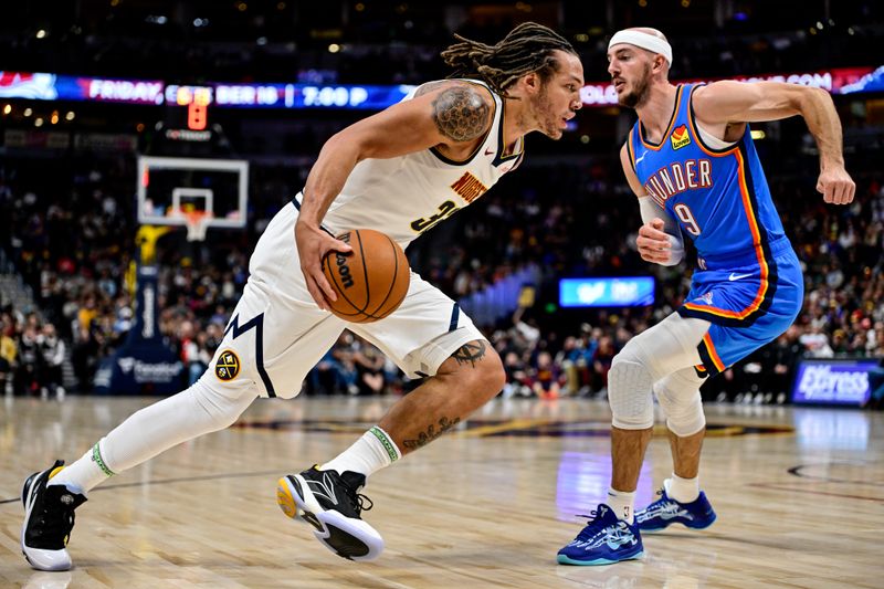 DENVER, COLORADO - OCTOBER 25: Aaron Gordon #32 of the Denver Nuggets dribbles the ball while defended by Alex Caruso #9 of the Oklahoma City Thunder in the second half at Ball Arena on October 15, 2024 in Denver, Colorado. NOTE TO USER: User expressly acknowledges and agrees that, by downloading and or using this photograph, User is consenting to the terms and conditions of the Getty Images License Agreement. (Photo by Dustin Bradford/Getty Images)