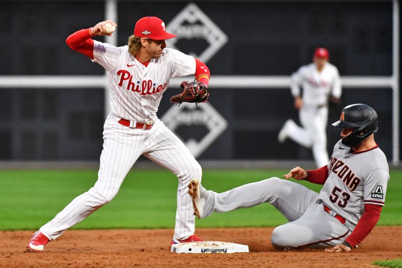 Oct 23, 2023; Philadelphia, Pennsylvania, USA; Philadelphia Phillies second baseman Bryson Stott (5) turns a double play over Arizona Diamondbacks first baseman Christian Walker (53) during the third inning in game six of the NLCS for the 2023 MLB playoffs at Citizens Bank Park. Mandatory Credit: Eric Hartline-USA TODAY Sports