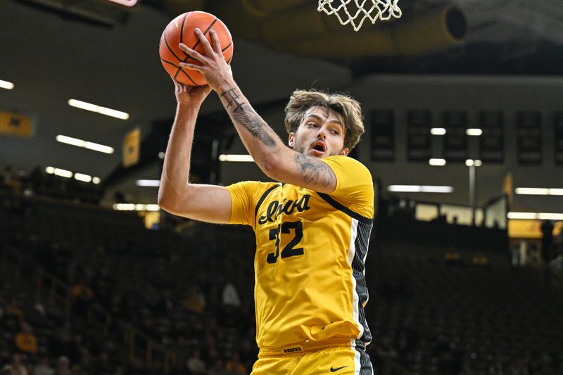 Dec 3, 2024; Iowa City, Iowa, USA; Iowa Hawkeyes forward Owen Freeman (32) secures a rebound against the Northwestern Wildcats during the first half at Carver-Hawkeye Arena. Mandatory Credit: Jeffrey Becker-Imagn Images