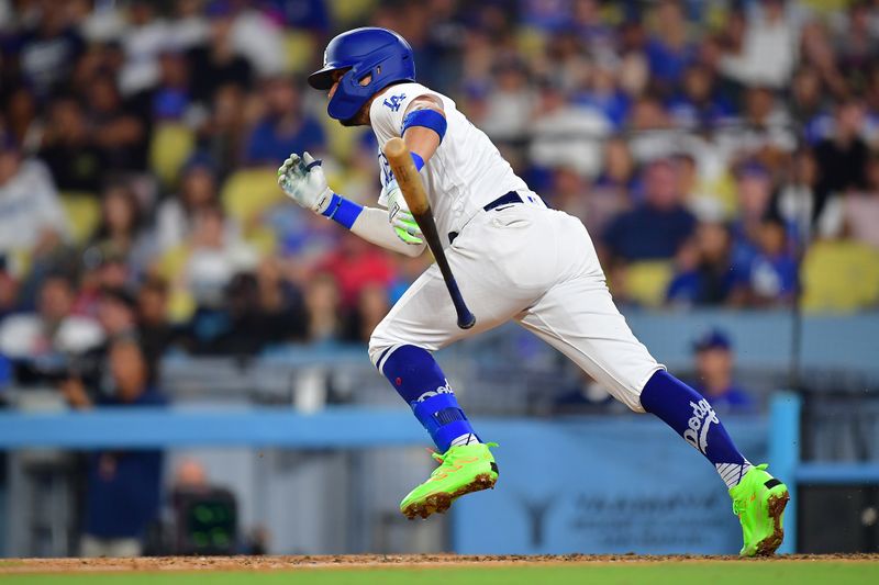 September 1, 2023; Los Angeles, California, USA; Los Angeles Dodgers shortstop Miguel Rojas (11) reaches first on a fielders choice against the Atlanta Braves during the eighth inning at Dodger Stadium. Mandatory Credit: Gary A. Vasquez-USA TODAY Sports