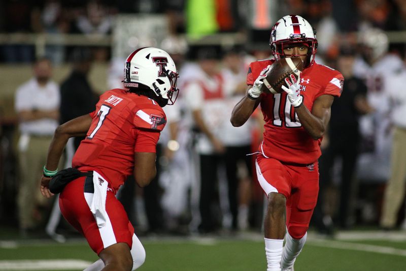 Nov 20, 2021; Lubbock, Texas, USA; Texas Tech Red Raiders quarterback Donovan Smith (7) flips the ball to wide receiver Kaylon Geiger Sr. (10) against the Oklahoma State Cowboys in the second half at Jones AT&T Stadium. Mandatory Credit: Michael C. Johnson-USA TODAY Sports