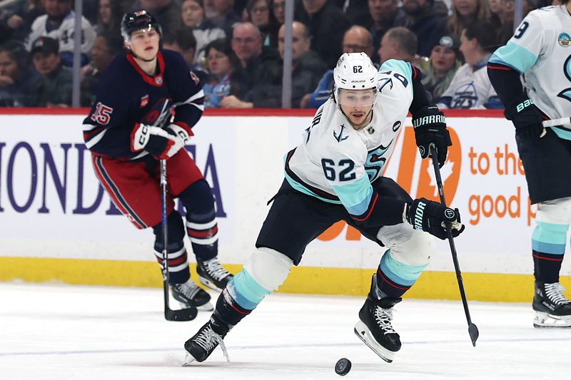 Jan 16, 2025; Winnipeg, Manitoba, CAN; Seattle Kraken defenseman Brandon Montour (62) skates past Winnipeg Jets center Rasmus Kupari (15) in the first period at Canada Life Centre. Mandatory Credit: James Carey Lauder-Imagn Images