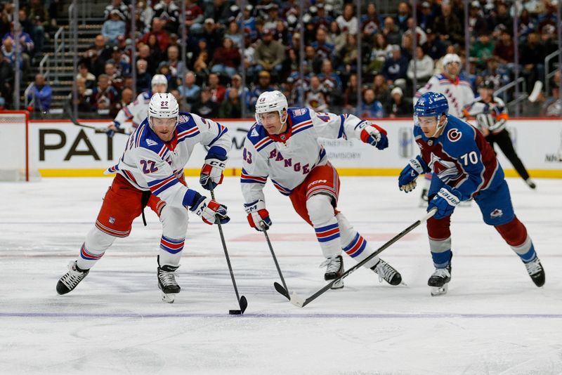 Nov 20, 2025; Denver, Colorado, USA; New York Rangers center Jonny Brodzinski (22) controls the puck ahead of left wing Conor Sheary (43) and Colorado Avalanche defenseman Sam Malinski (70) in the first period at Ball Arena. Mandatory Credit: Isaiah J. Downing-Imagn Images