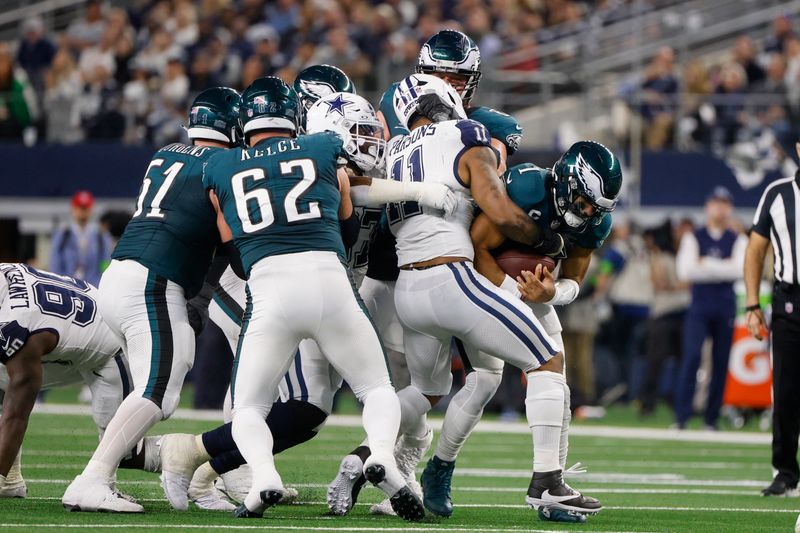 Dallas Cowboys linebacker Micah Parsons, second from right, sacks Philadelphia Eagles quarterback Jalen Hurts, right, during the first half of an NFL football game, Sunday, Dec. 10, 2023, in Arlington, Texas. (AP Photo/Michael Ainsworth)