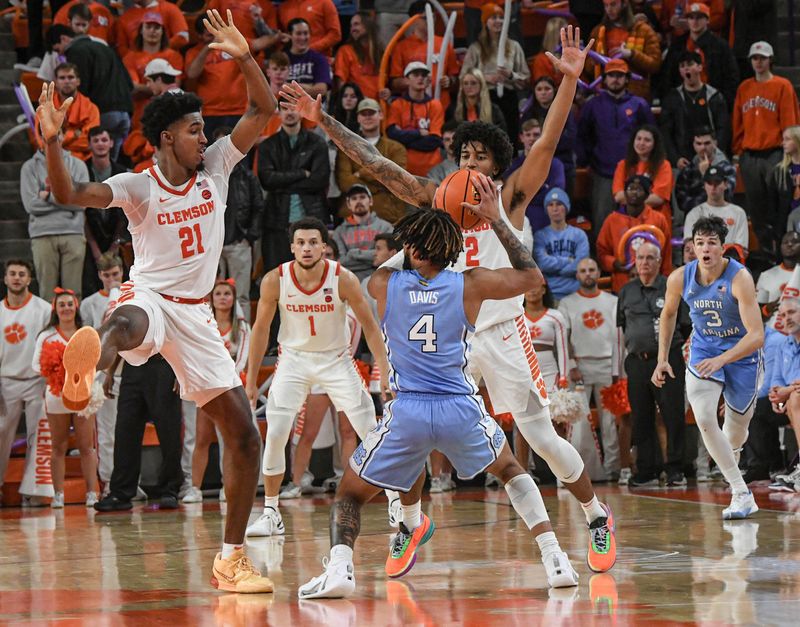 Jan 6, 2024; Clemson, South Carolina, USA; Clemson sophomore forward Chauncey Wiggins (21) and Clemson sophomore guard Dillon Hunter (2) guard University of North Carolina guard RJ Davis (4) during the second half at Littlejohn Coliseum. Mandatory Credit: Ken Ruinard-USA TODAY Sports