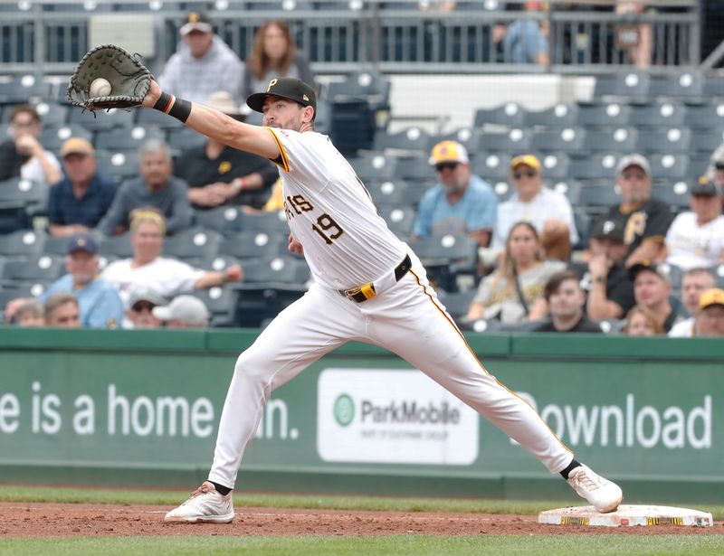 Sep 26, 2024; Pittsburgh, Pennsylvania, USA;  Pittsburgh Pirates first baseman Jared Triolo (19) takes a wide throw to retire Milwaukee Brewers left fielder Sal Frelick (not pictured) during the sixth inning at PNC Park. Mandatory Credit: Charles LeClaire-Imagn Images