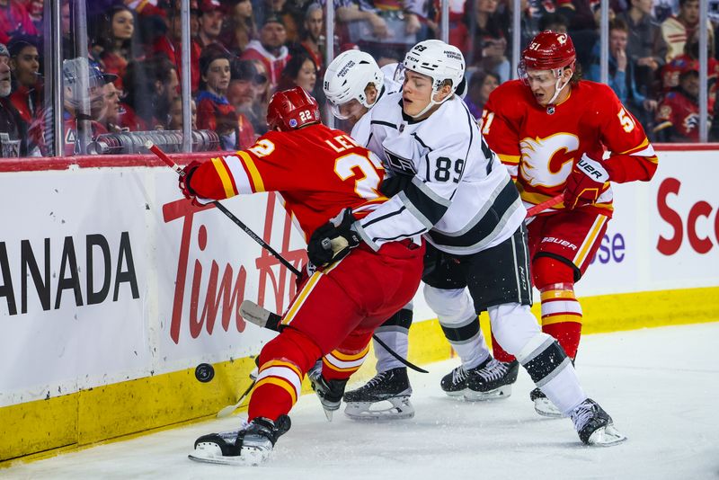 Mar 28, 2023; Calgary, Alberta, CAN; Los Angeles Kings center Rasmus Kupari (89) and Calgary Flames center Trevor Lewis (22) battle for the puck during the first period at Scotiabank Saddledome. Mandatory Credit: Sergei Belski-USA TODAY Sports