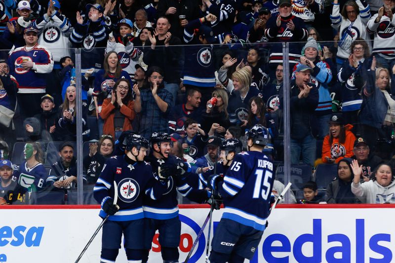 Apr 18, 2024; Winnipeg, Manitoba, CAN;  Winnipeg Jets forward Cole Perfetti (91) is congratulated by his team mates on his goal against the Vancouver Canucks during the second period at Canada Life Centre. Mandatory Credit: Terrence Lee-USA TODAY Sports