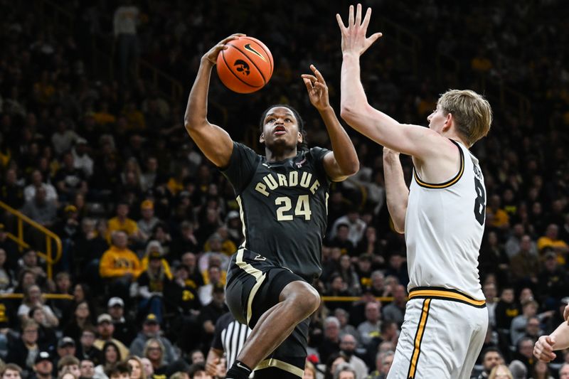 Feb 14, 2026; Iowa City, Iowa, USA; Purdue Boilermakers guard Gicarri Harris (24) goes to the basket as Iowa Hawkeyes forward Cooper Koch (8) defends during the first half at Carver-Hawkeye Arena. Mandatory Credit: Jeffrey Becker-Imagn Images