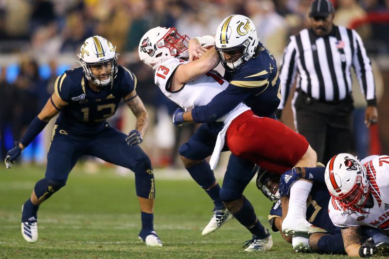 Nov 21, 2019; Atlanta, GA, USA; North Carolina State Wolfpack quarterback Devin Leary (13) is tackled by Georgia Tech Yellow Jackets defensive back Kaleb Oliver (22) in the first half at Bobby Dodd Stadium. Mandatory Credit: Brett Davis-USA TODAY Sports