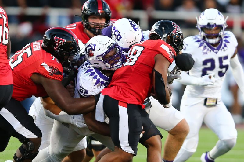 Nov 2, 2023; Lubbock, Texas, USA; Texas Tech Red Raiders running back Tahj Brooks (28) is tackled by Texas Christian Horned Frogs defensive tackle Damonic Williams (52) in the first half at Jones AT&T Stadium and Cody Campbell Field. Mandatory Credit: Michael C. Johnson-USA TODAY Sports