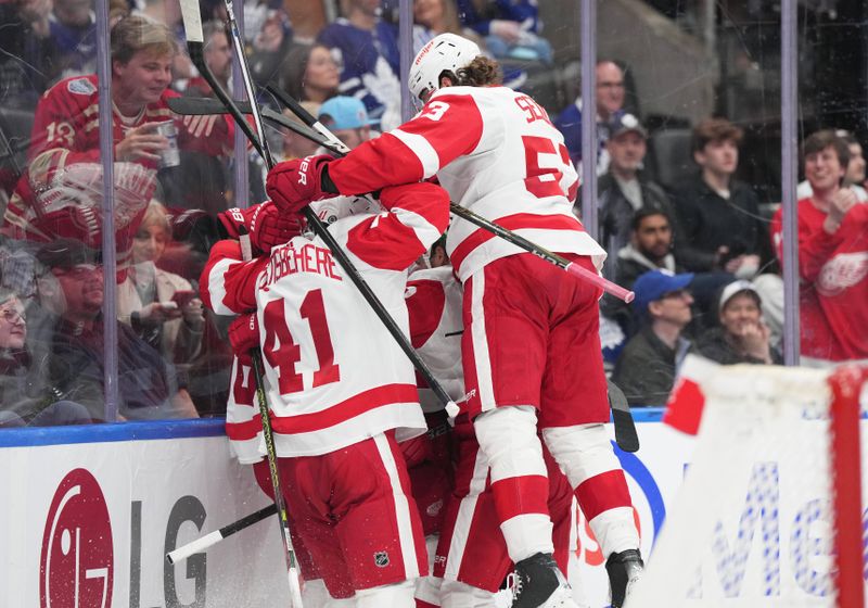 Apr 13, 2024; Toronto, Ontario, CAN; Detroit Red Wings defenseman Moritz Seider (53) celebrates the win with defenseman Shayne Gostisbehere (41) against the Toronto Maple Leafs during the overtime period at Scotiabank Arena. Mandatory Credit: Nick Turchiaro-USA TODAY Sports