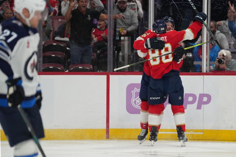 Nov 16, 2024; Sunrise, Florida, USA;  Florida Panthers defenseman Nate Schmidt (88) celebrates with center Sam Bennett (9) after a goal against the Winnipeg Jets during the second period at Amerant Bank Arena. Mandatory Credit: Jim Rassol-Imagn Images