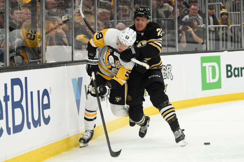 Jan 4, 2024; Boston, Massachusetts, USA; Boston Bruins defenseman Hampus Lindholm (27) checks Pittsburgh Penguins left wing Jake Guentzel (59) during the second period at TD Garden. Mandatory Credit: Bob DeChiara-USA TODAY Sports