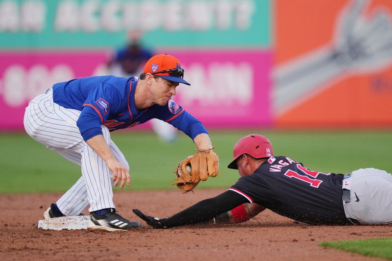 Mar 15, 2024; Port St. Lucie, Florida, USA; Washington Nationals shortstop Ildemaro Vargas (14) steals second base as New York Mets second baseman Joey Wendle (13) applies the tag in the second inning at Clover Park. Mandatory Credit: Jim Rassol-USA TODAY Sports